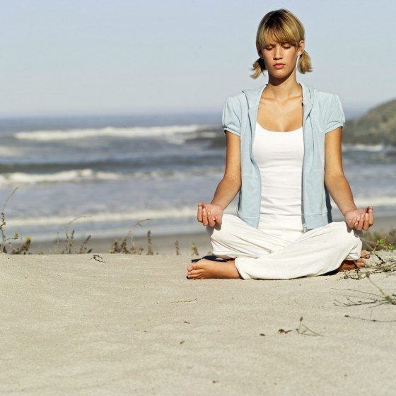 Young Woman Meditating at the Beach